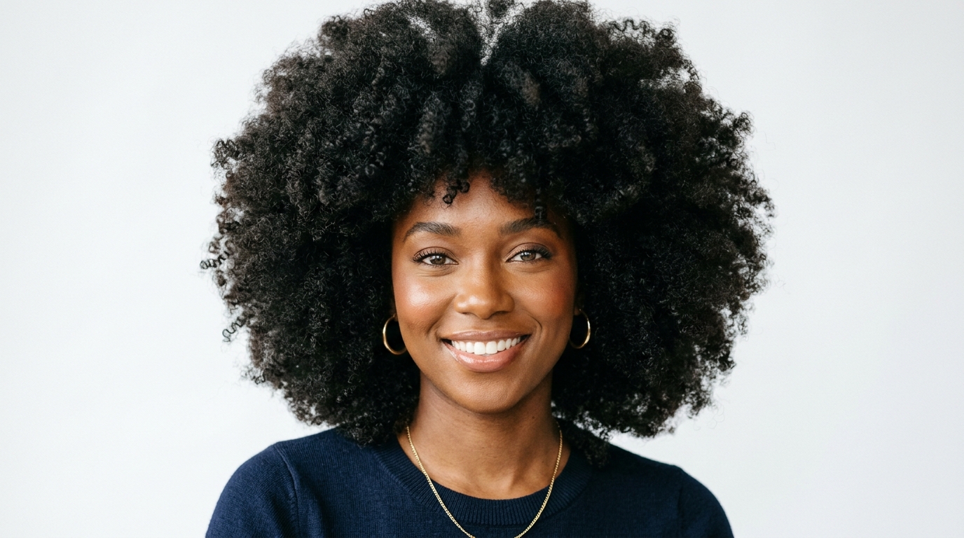 Beautiful Black woman with full natural Type 4 afro showcasing the incredible volume and versatility of coily hair